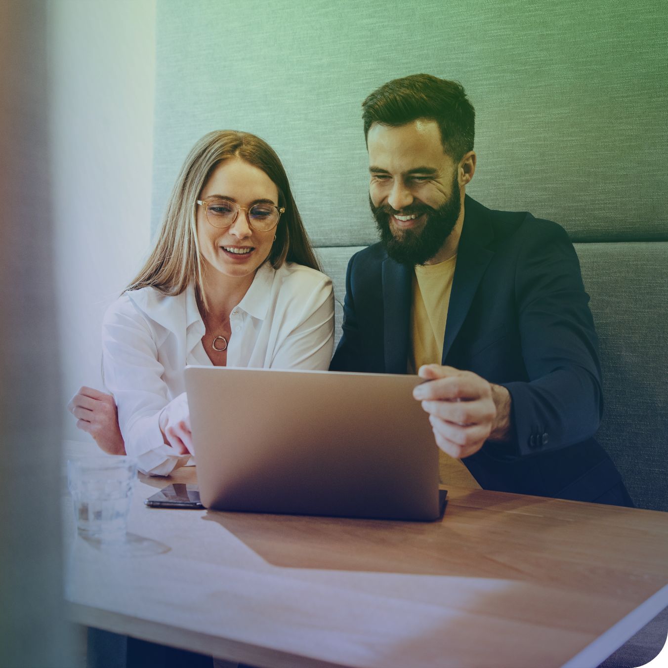 Twee personen werken samen aan een laptop